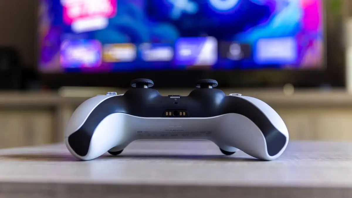 Fotografía de un DualSense de Sony y PlayStation frente a una pantalla